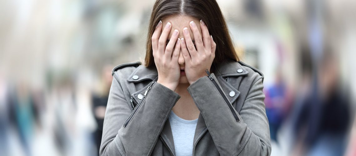 Woman suffering anxiety attack on city street