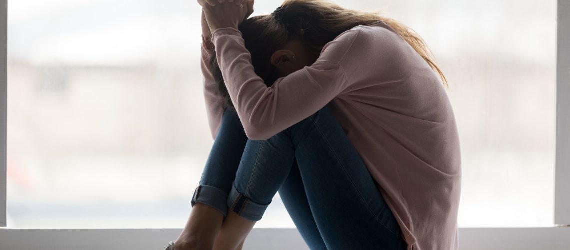 Depressed sad teen girl sit on sill crying alone at home, upset desperate young woman feeling frustrated anxious regret mistake suffer from unwanted teenage pregnancy abortion problem concept