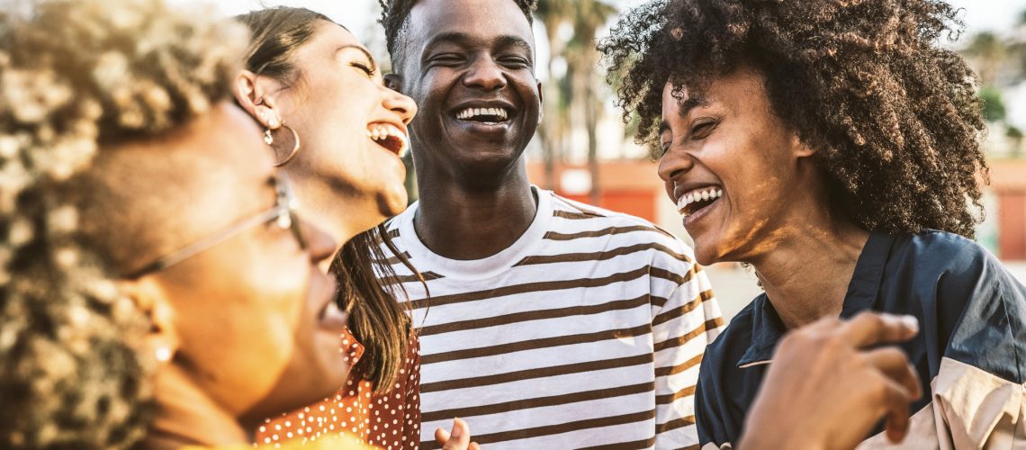 Young happy people laughing together - Multiracial friends group having fun on city street - Diverse culture students portrait celebrating outside - Friendship, community, youth, university concept