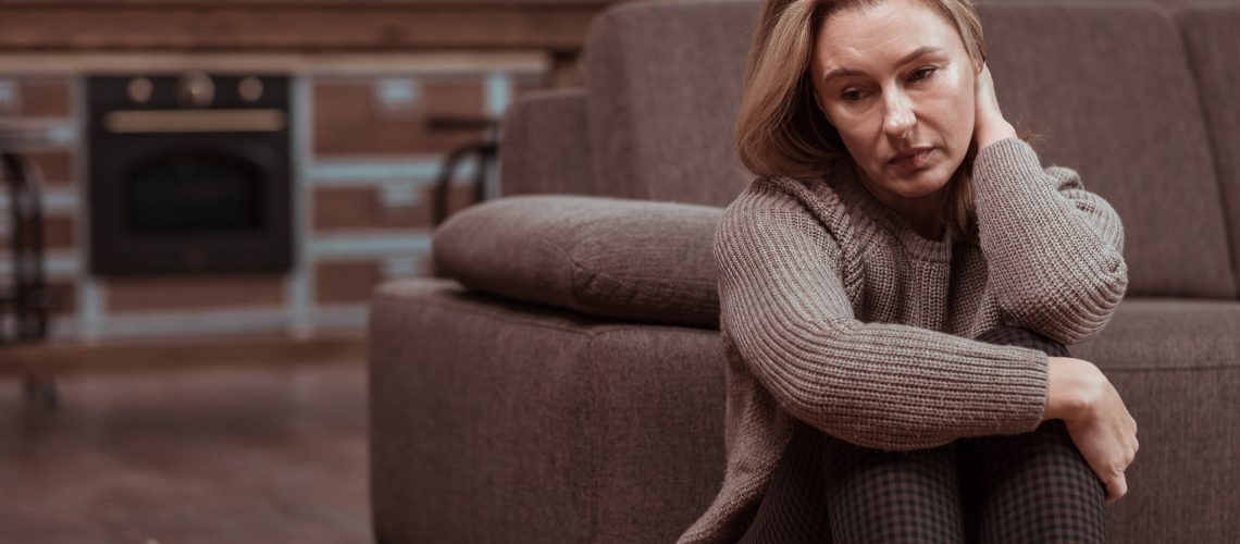 Feeling depressed. Woman wearing brown squared trousers feeling depressed after work problems